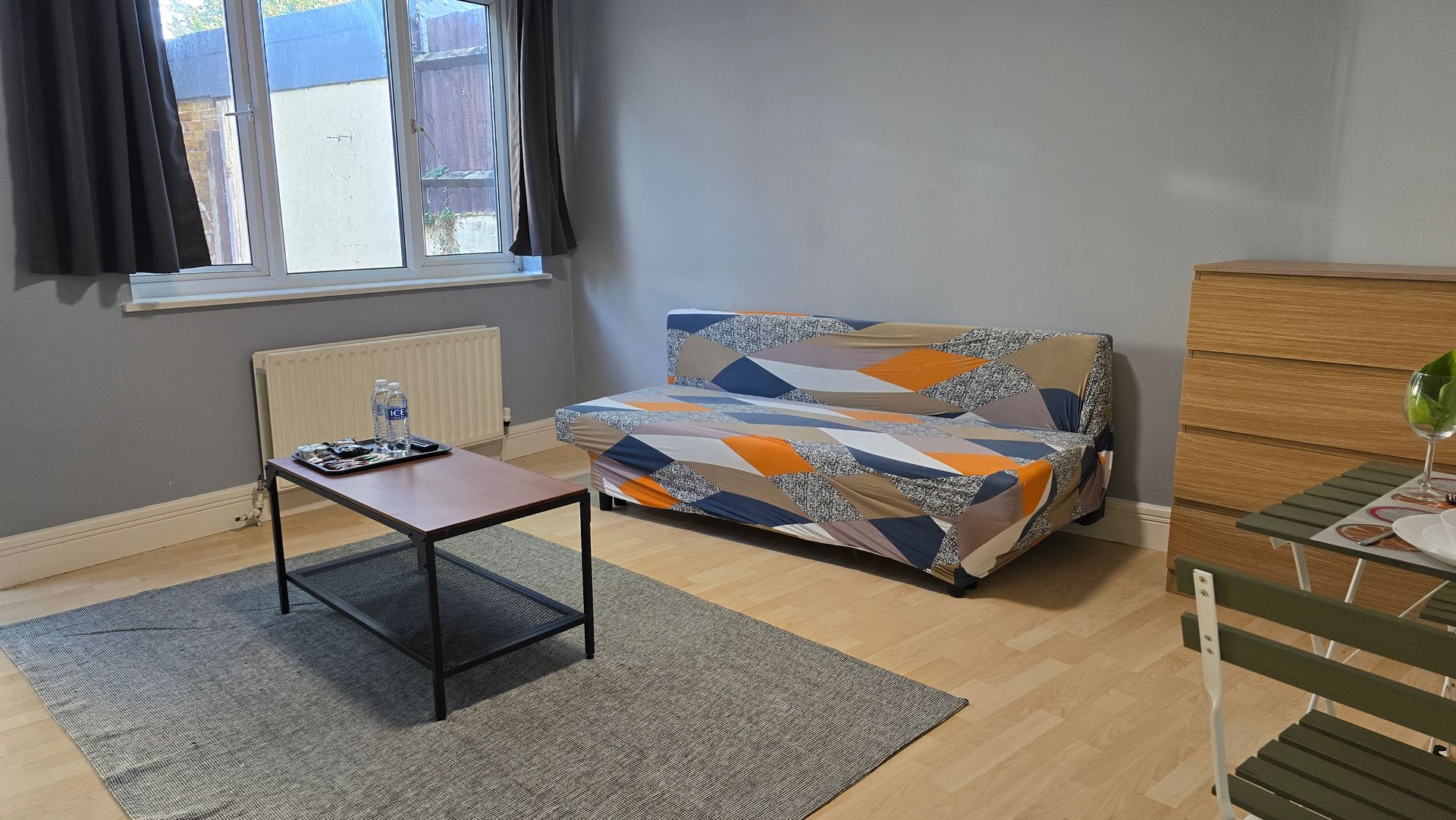 A living room with a couch , coffee table and chairs.