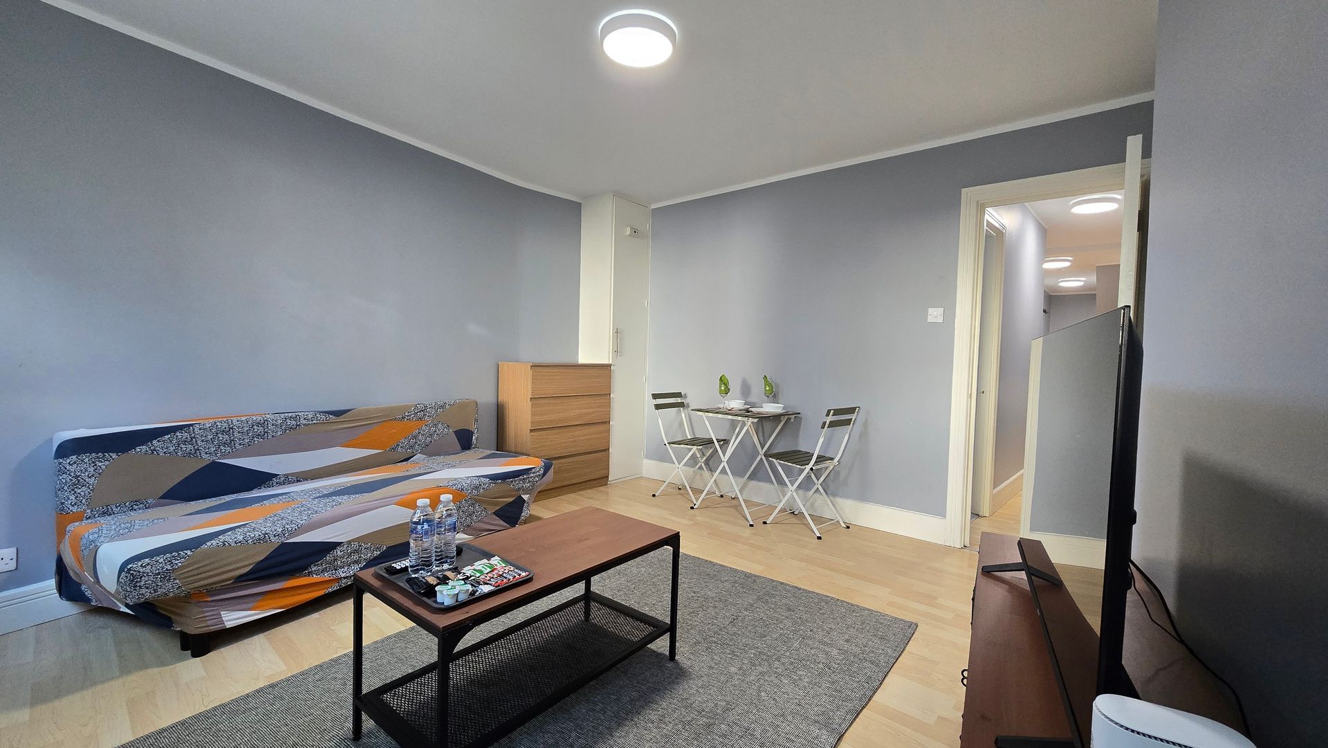 A living room with a couch , coffee table , and television.