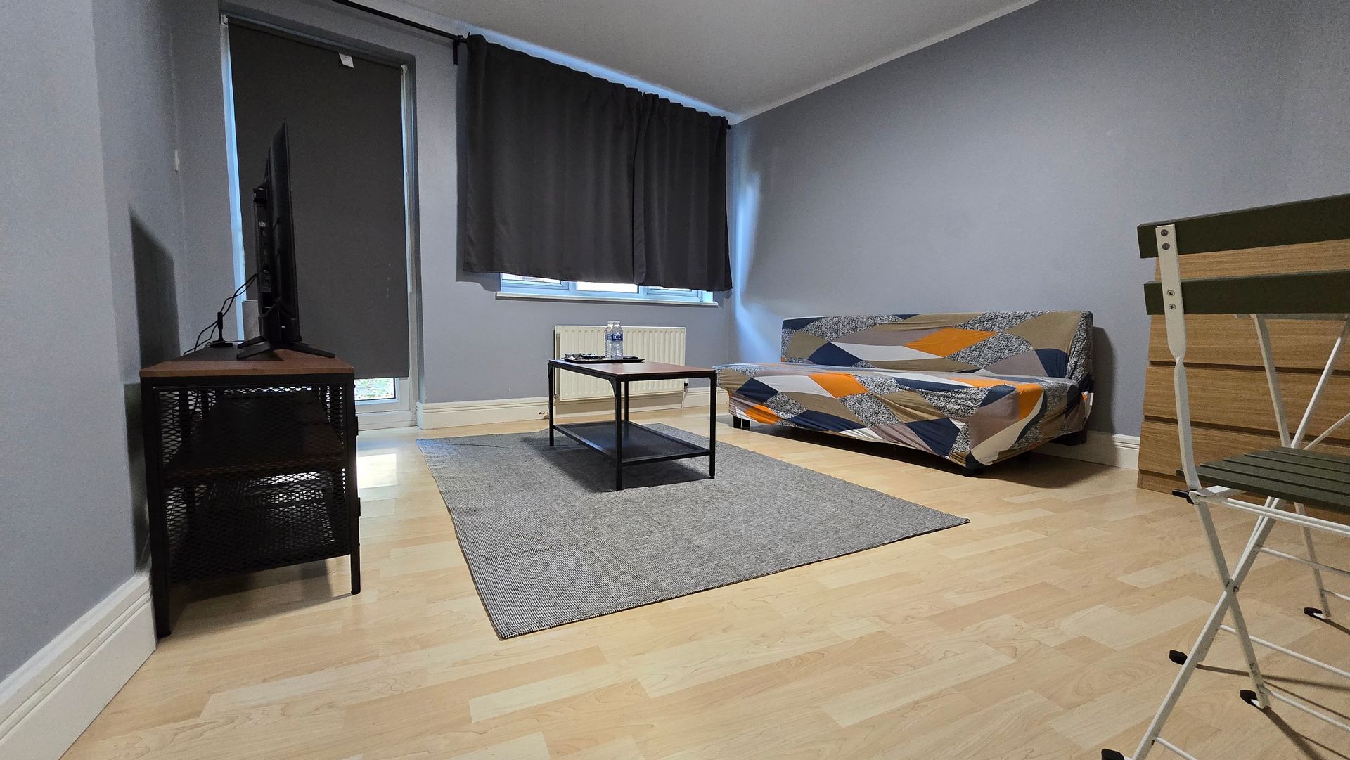 A living room with a couch , coffee table , chair and television.