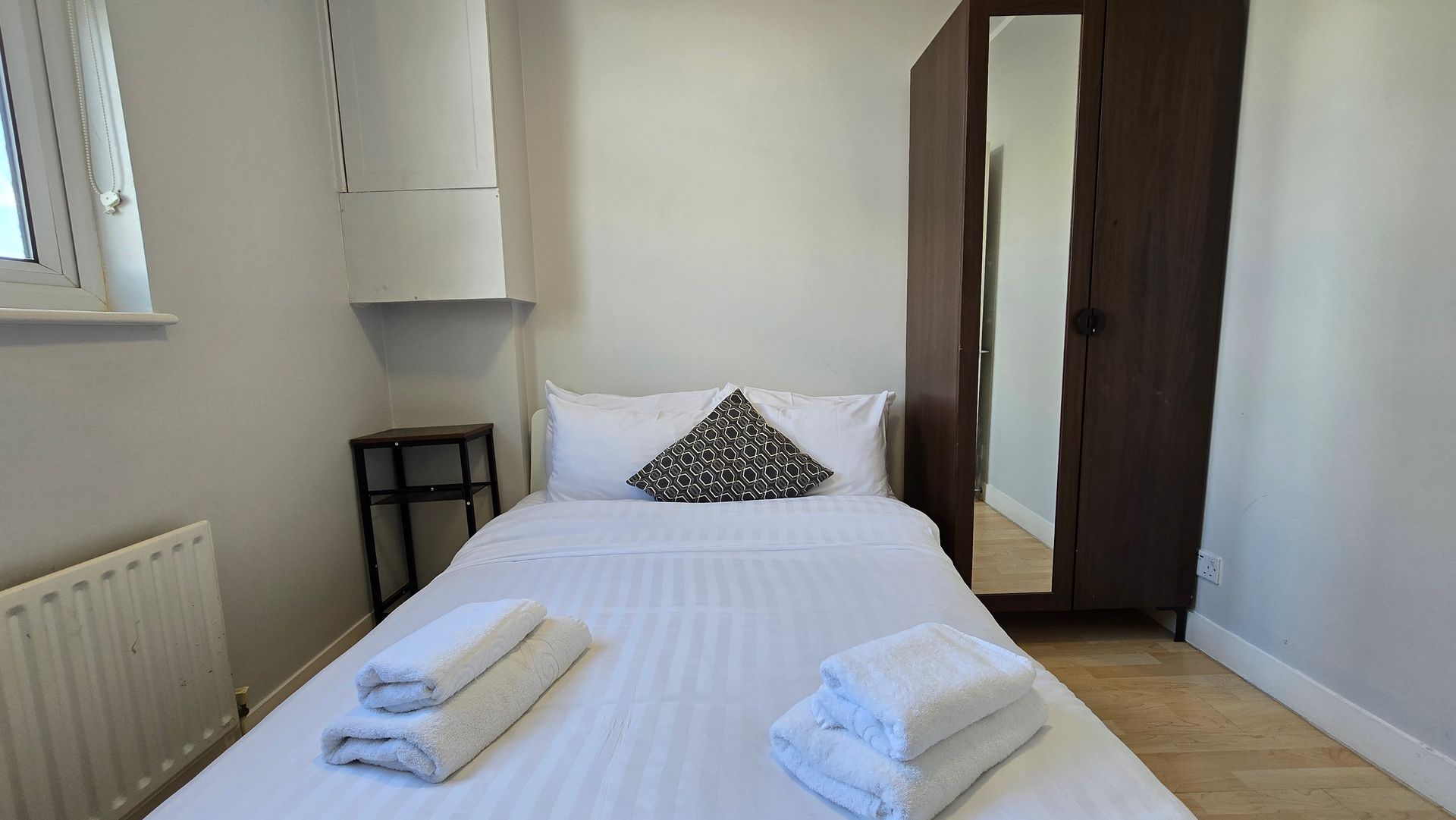 A small bedroom with a bed and a wardrobe