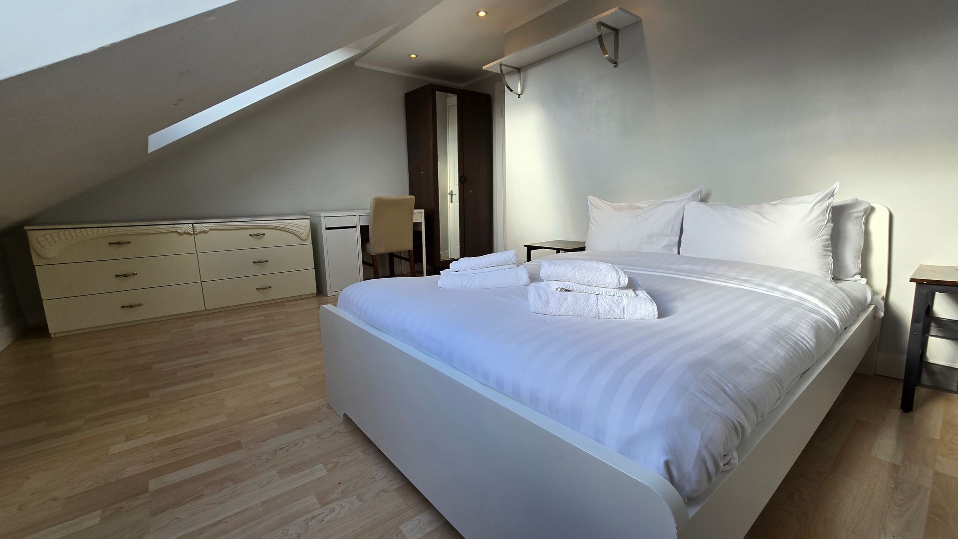 A bedroom with a king size bed and a desk