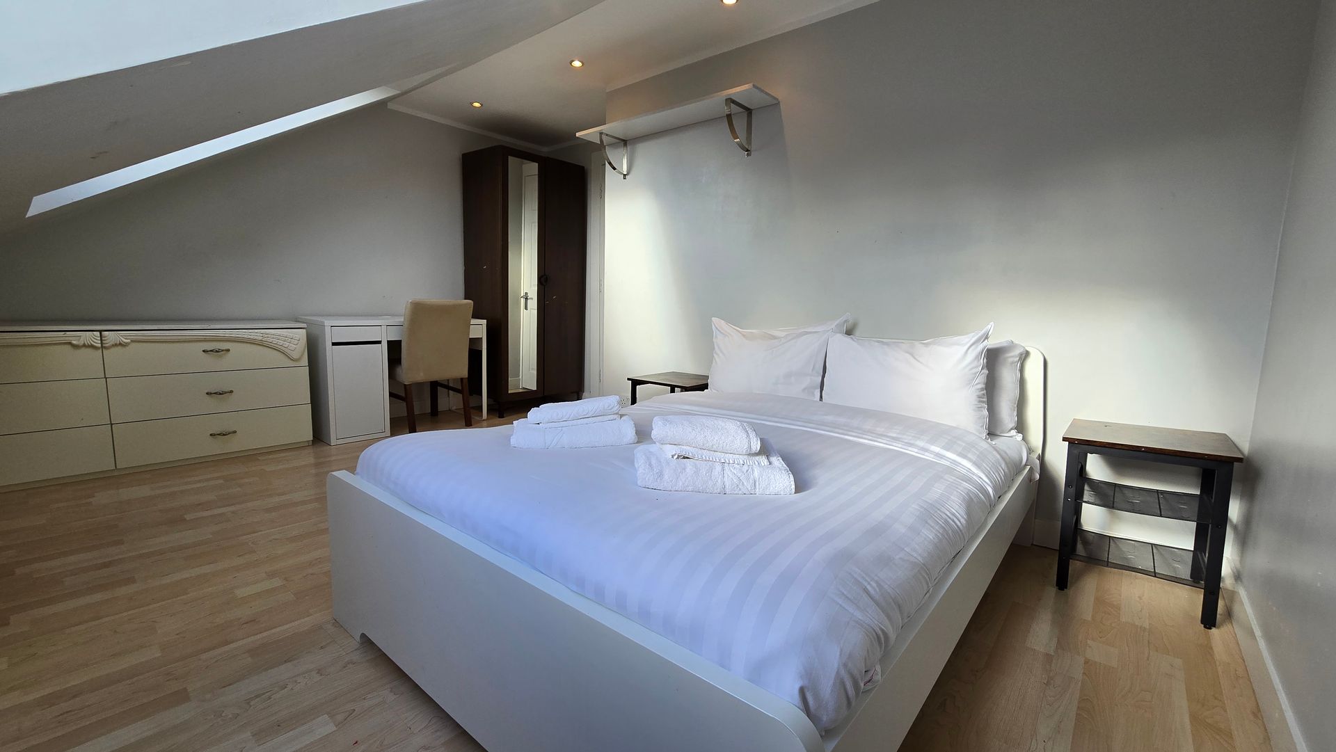 A bedroom with a large bed and a desk