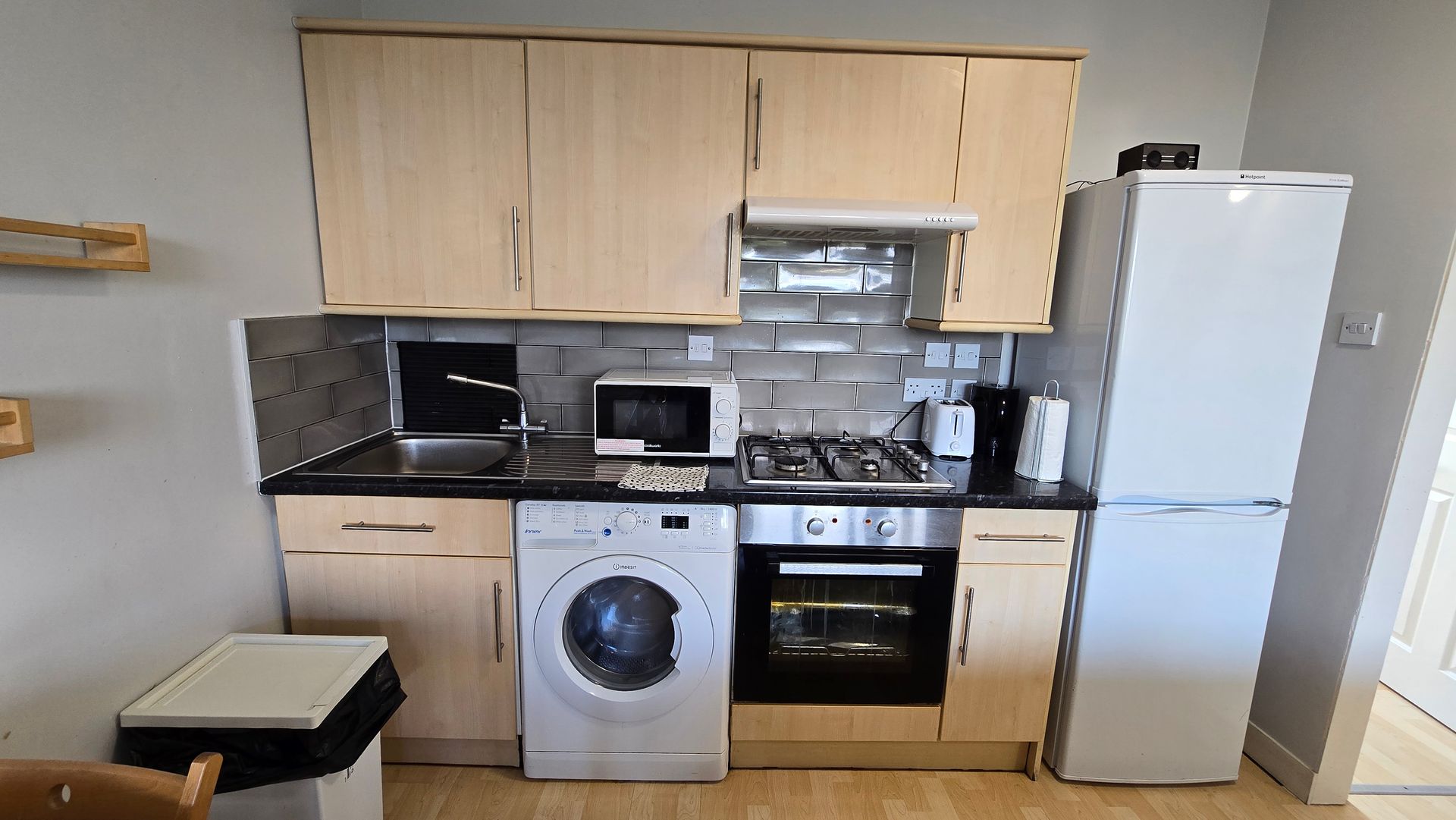 A kitchen with a washer and dryer and a refrigerator