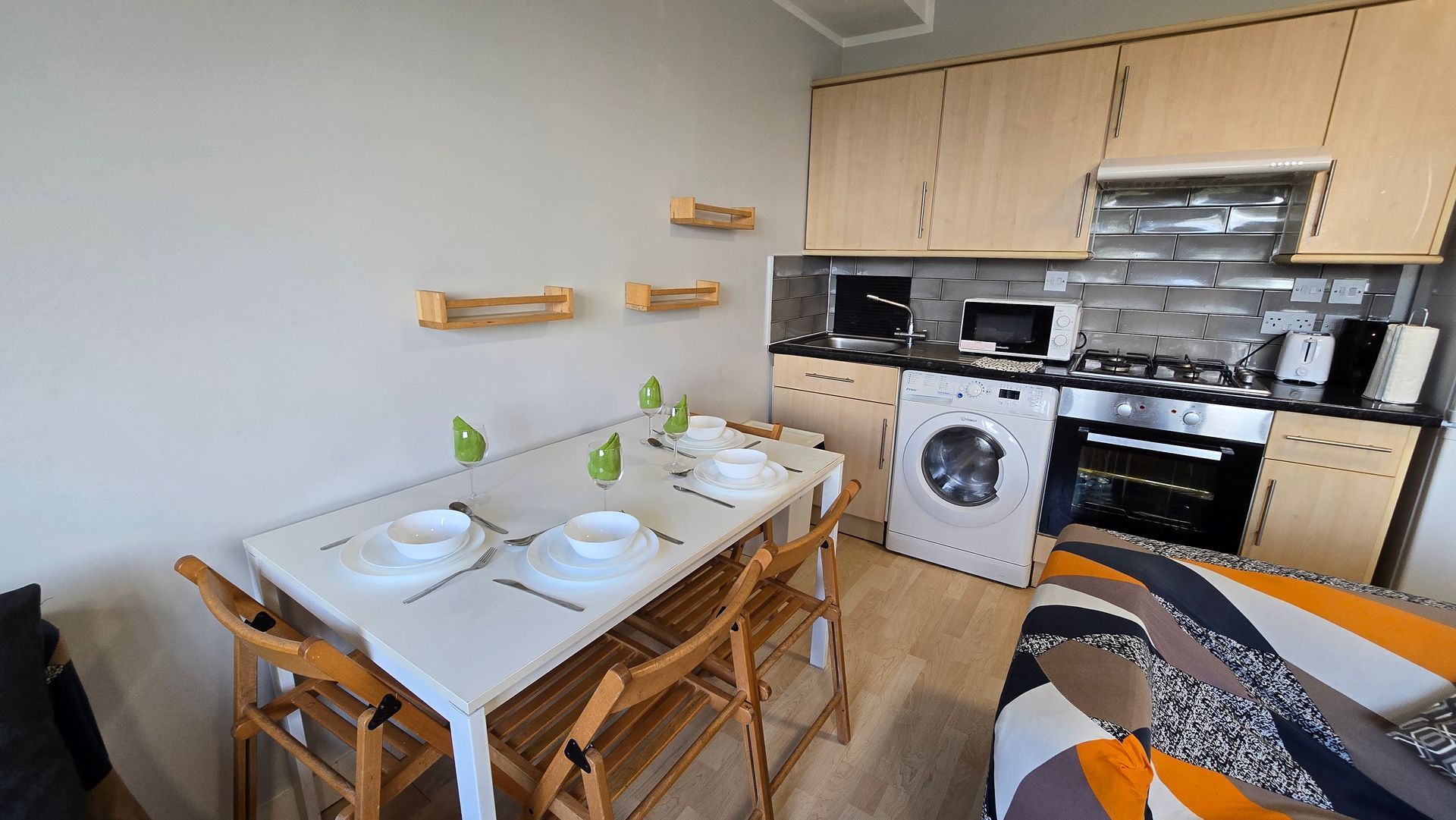 A kitchen with a table and chairs and a washing machine