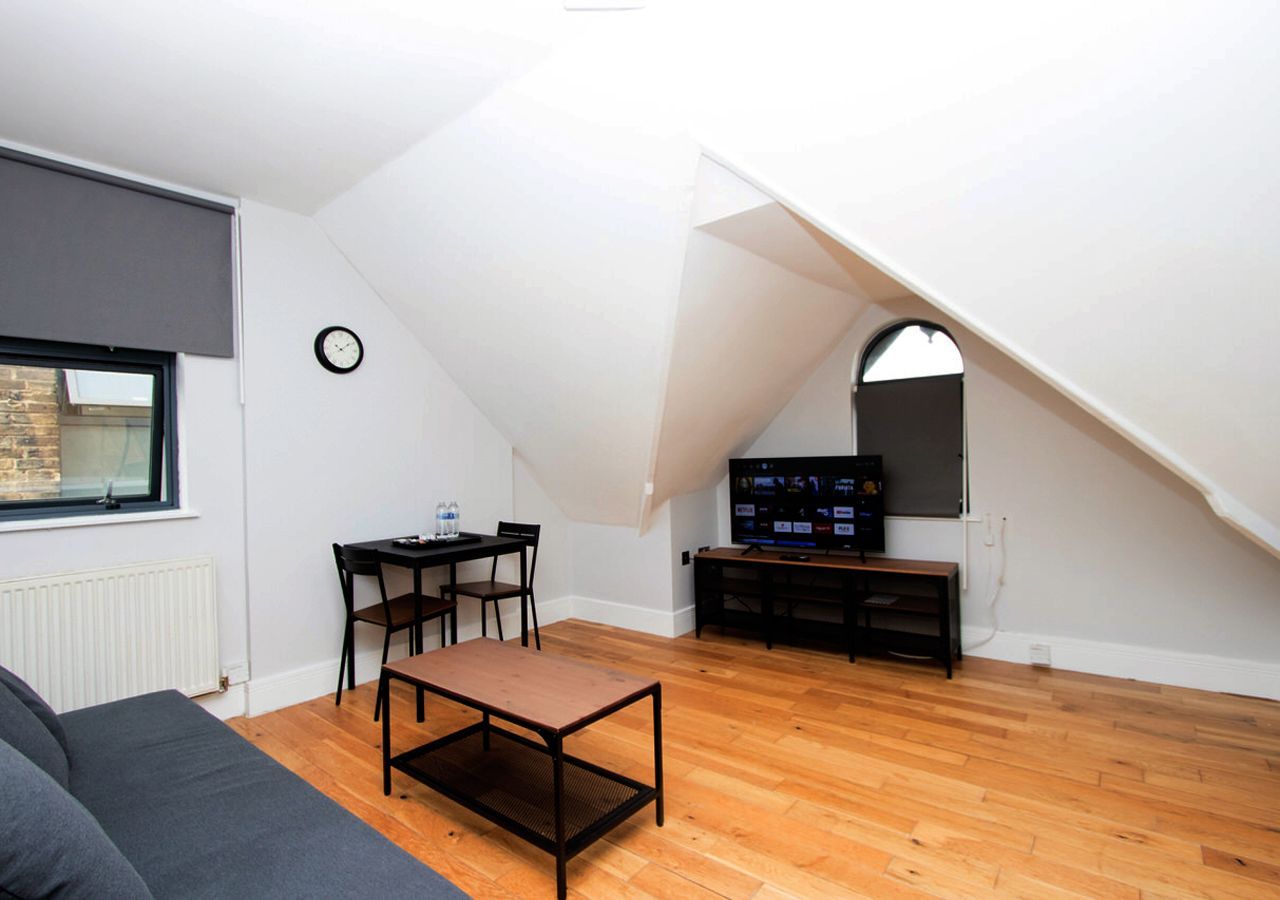 A living room with a couch a table and a television