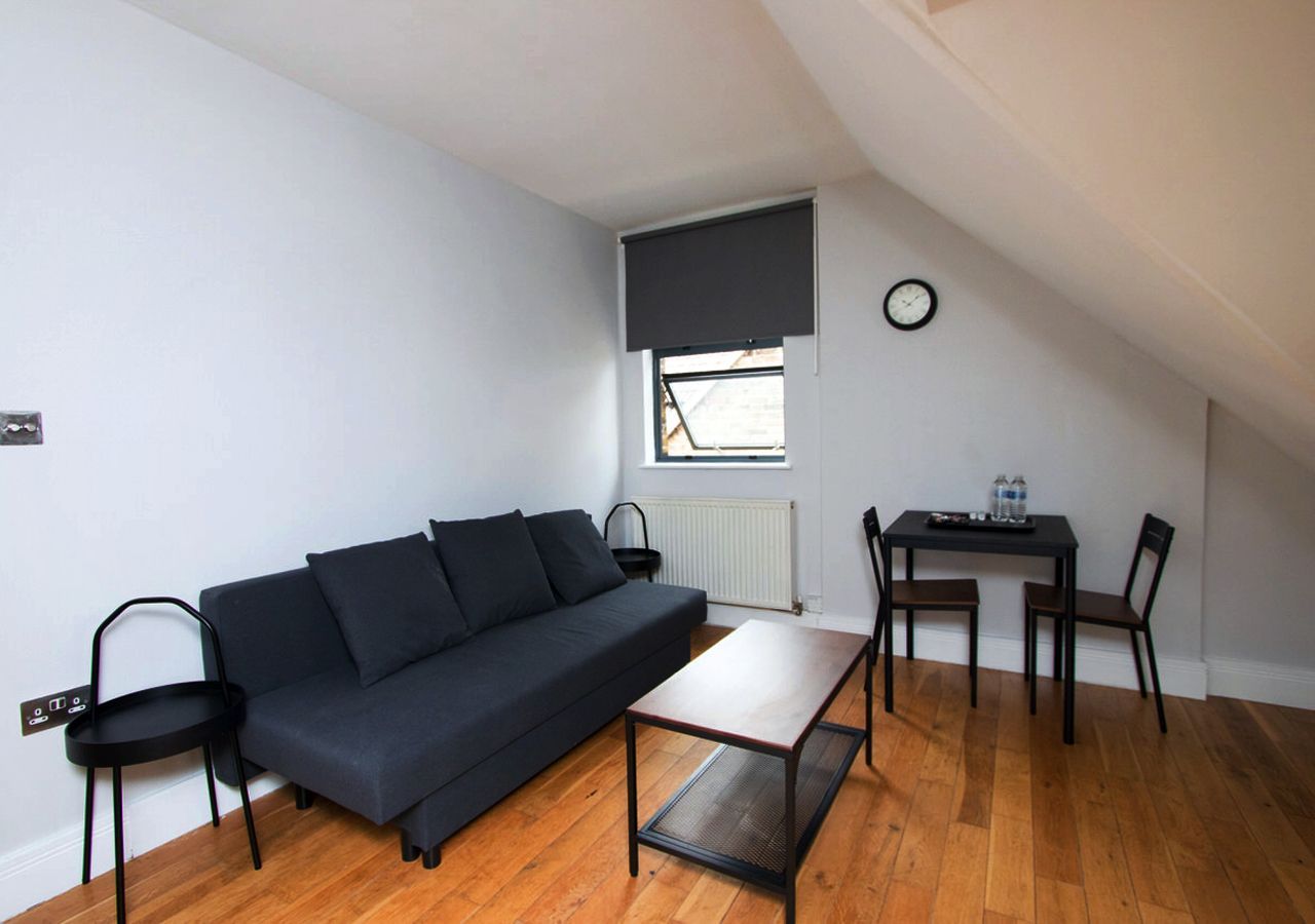 A living room with a couch , table and chairs