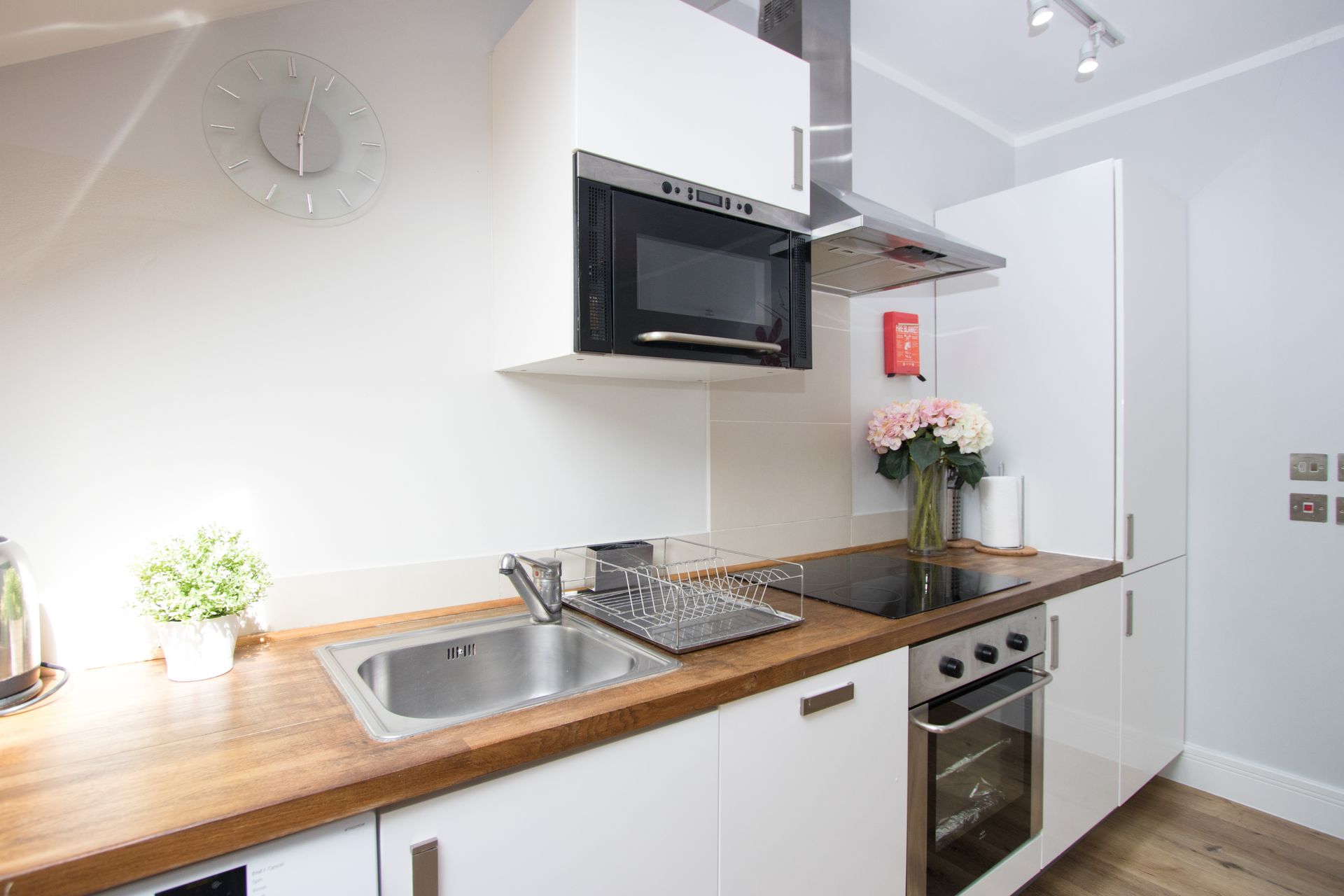 A kitchen with a sink , stove , microwave and oven.