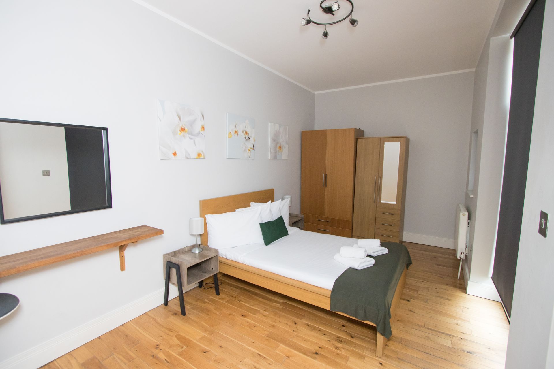 A bedroom with a bed and a mirror on the wall