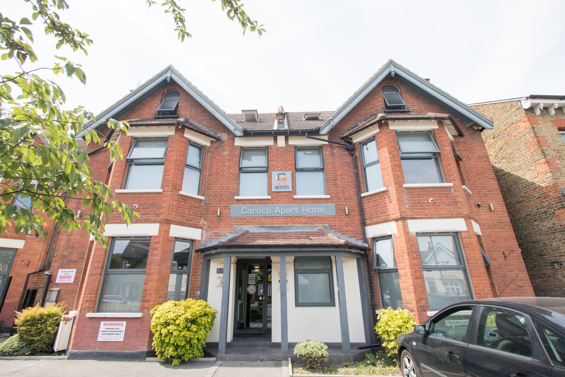 A large brick building with a car parked in front of it.