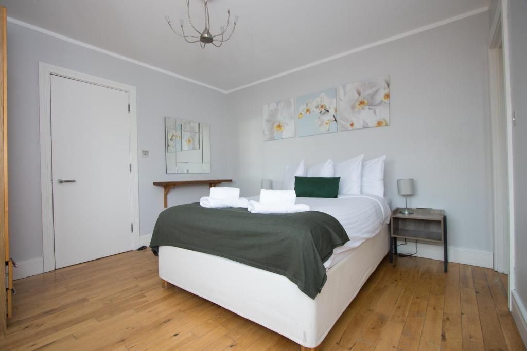 A bedroom with a large bed and a wooden floor