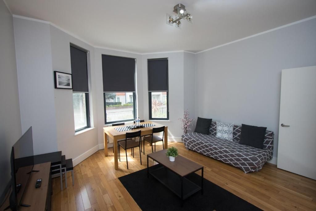 A living room with a couch , table and chairs