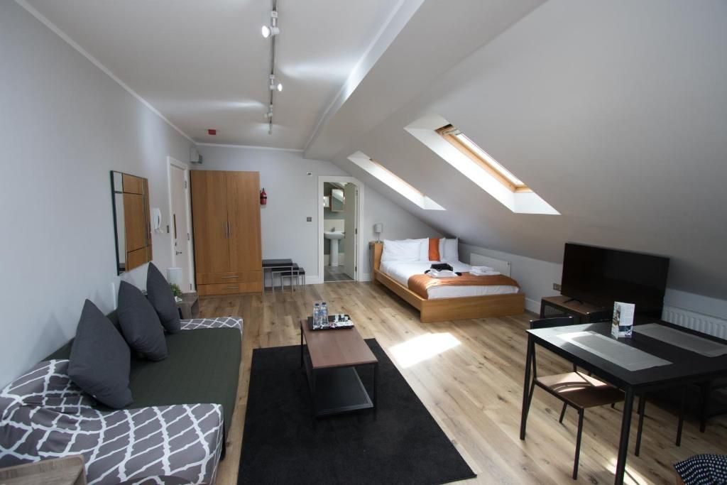 A living room with a couch a table and a bed