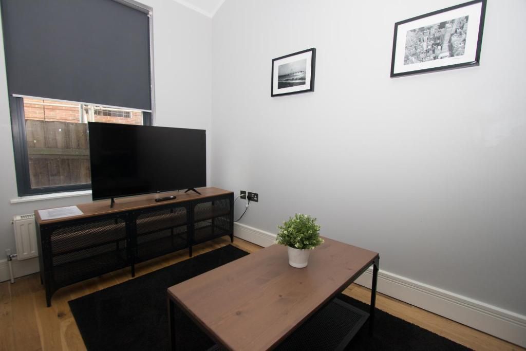 A living room with a coffee table and a flat screen tv.
