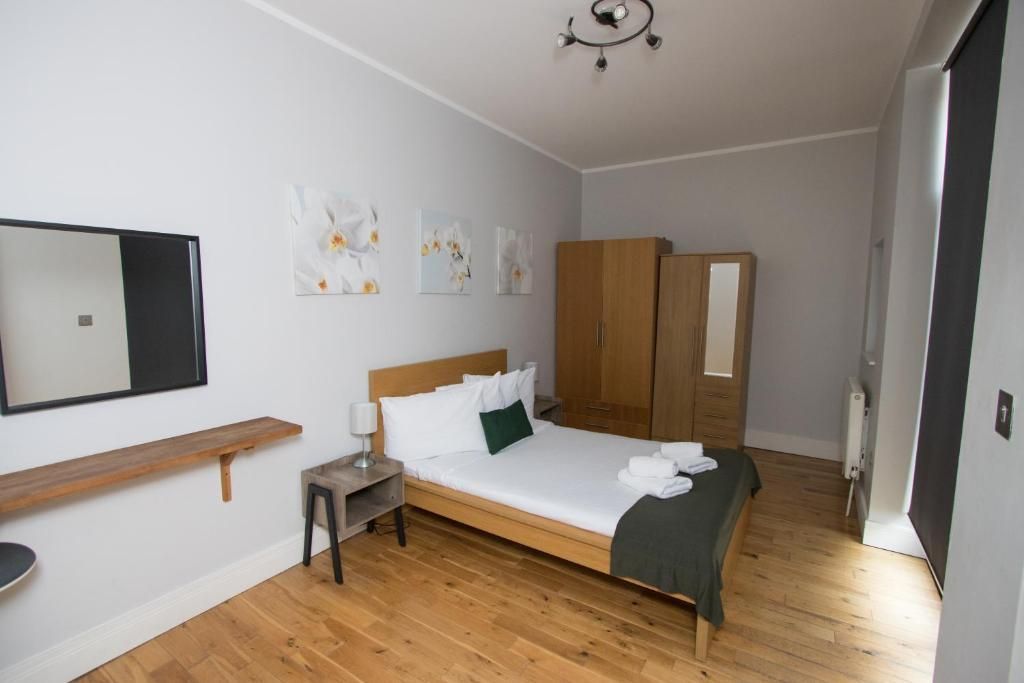 A bedroom with a bed and a mirror on the wall