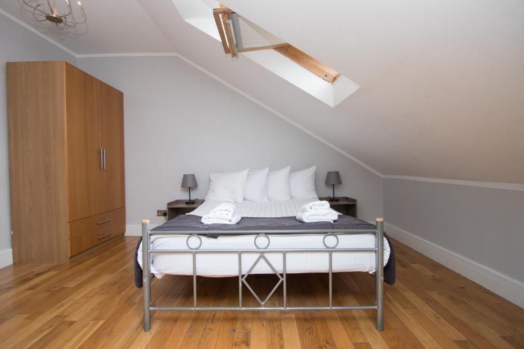 A bedroom with a king size bed and a skylight.