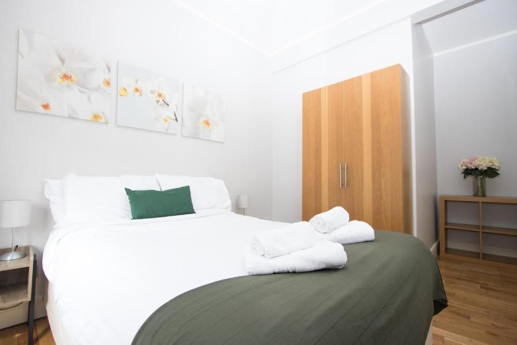 A bedroom with a large bed and a wooden wardrobe