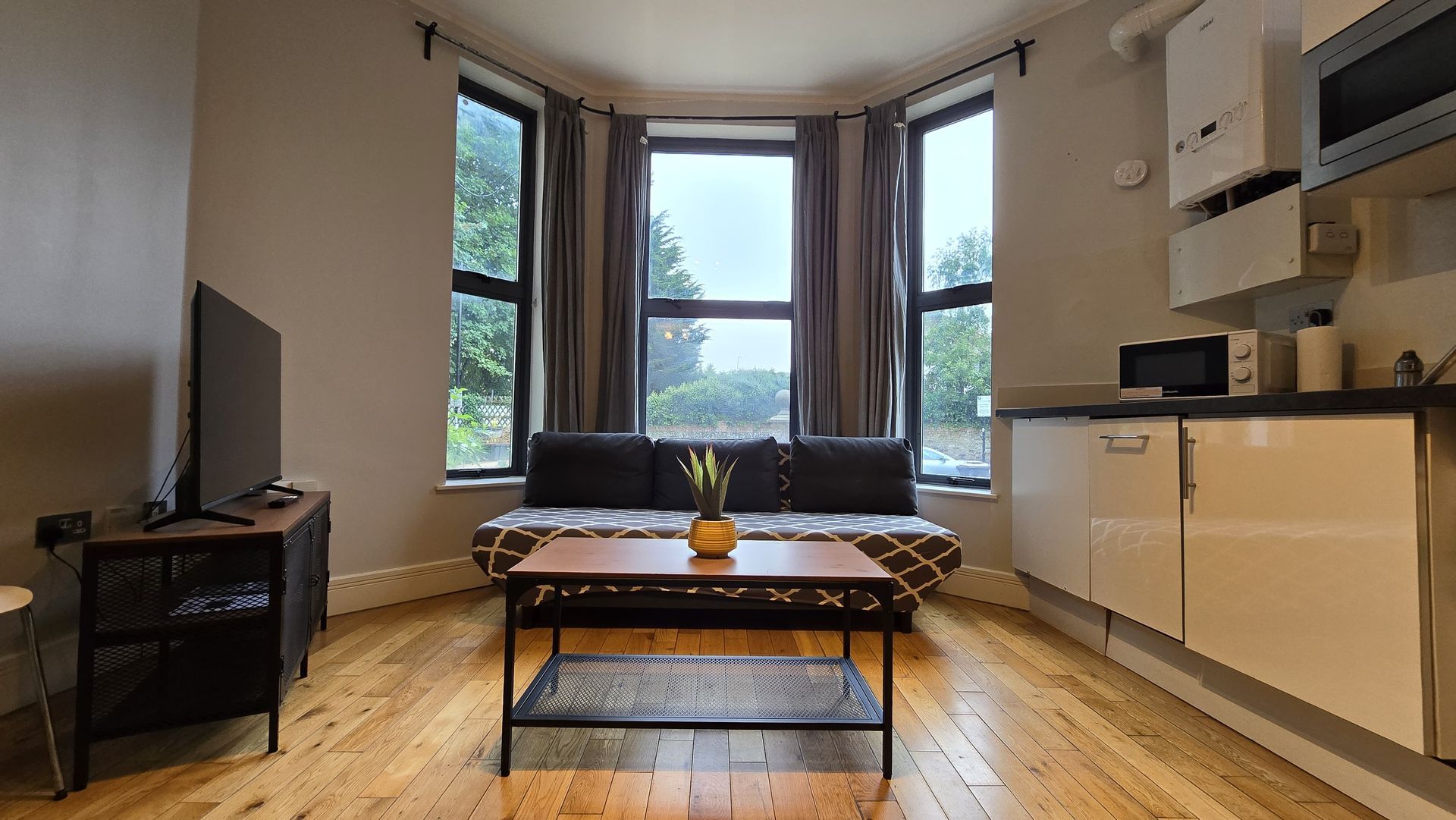 A living room with a couch , coffee table , and television.