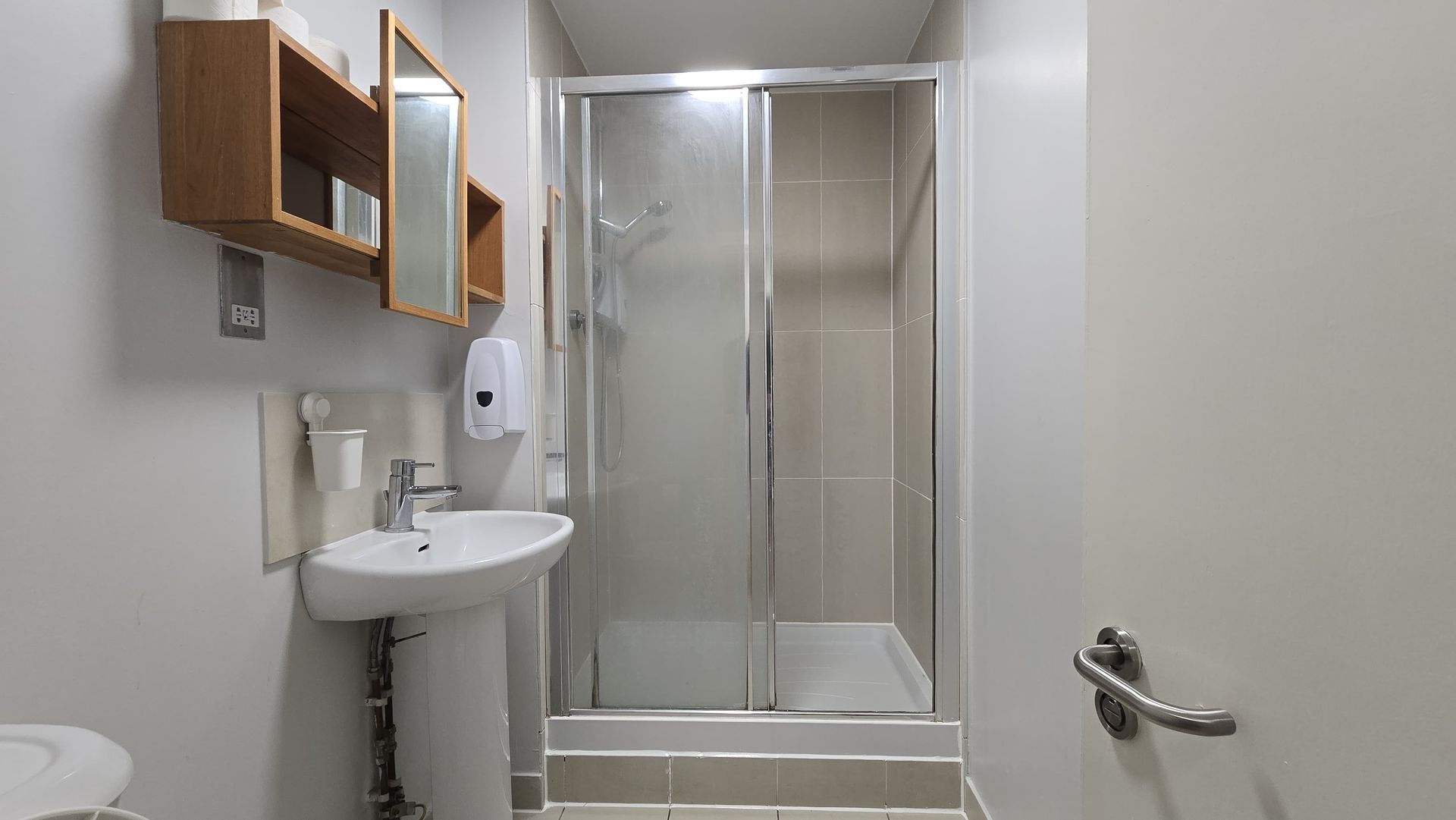 A bathroom with a sink , toilet and shower.