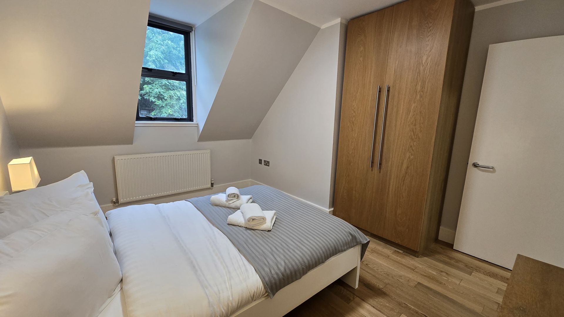 A bedroom with a large bed and a window.
