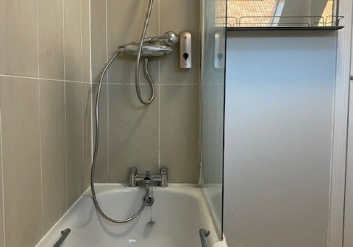 A bathroom with a bathtub and a shower.
