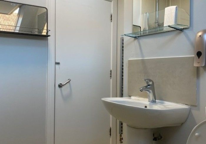 A bathroom with a sink and toilet and a mirror