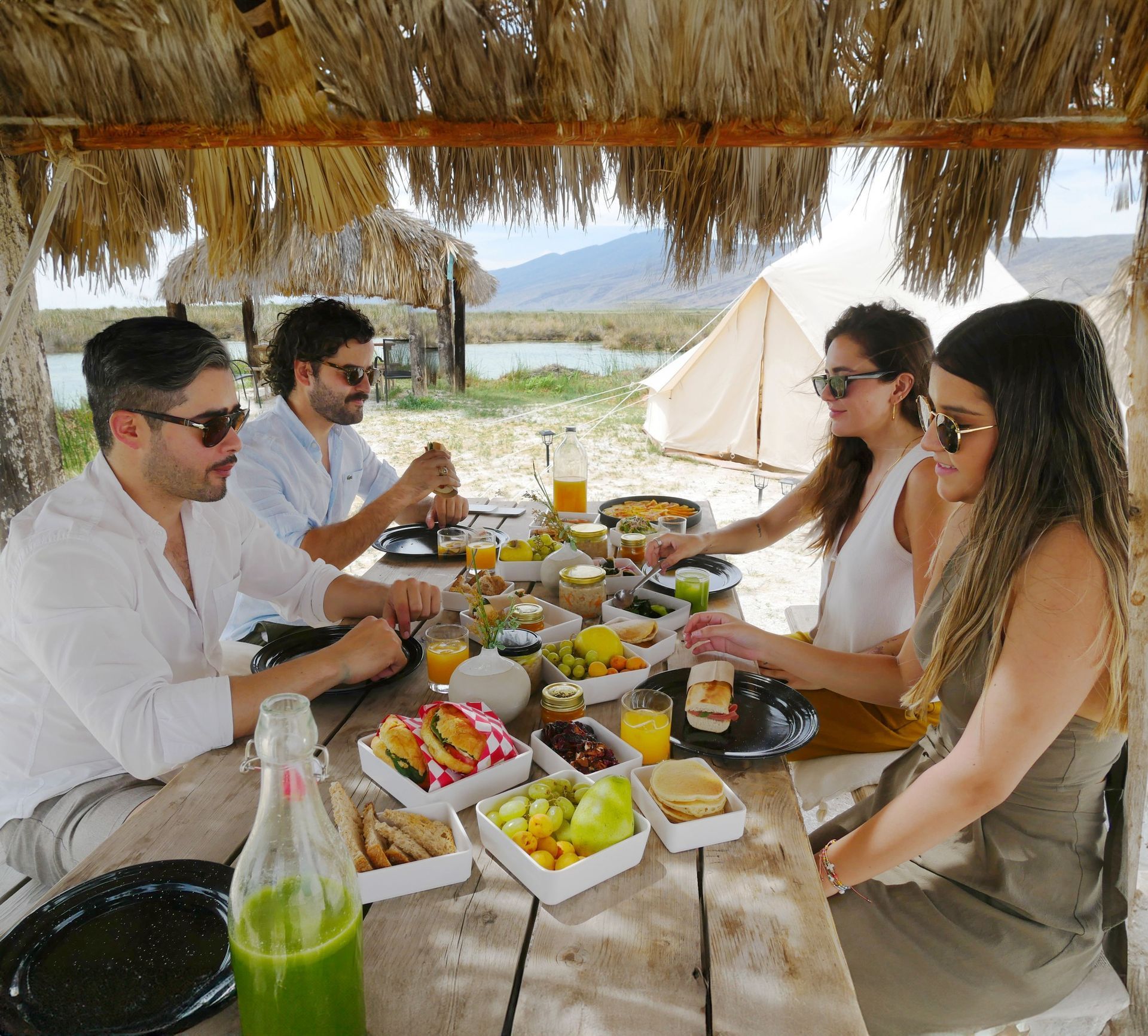 Un grupo de personas están sentadas en una mesa comiendo comida.