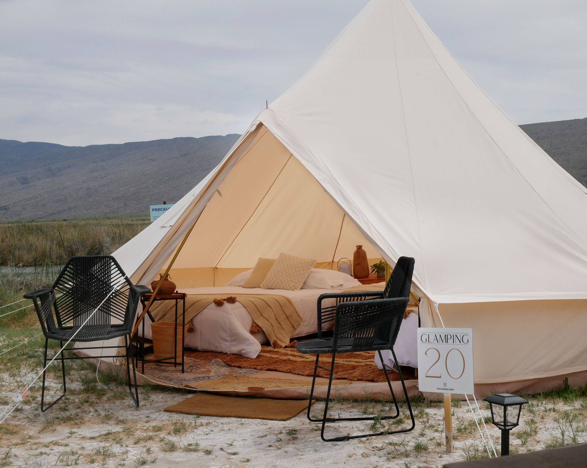 Una tienda de campaña con una cama y sillas delante y un cartel que dice 20