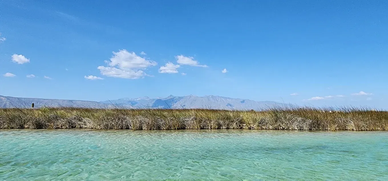 Un gran cuerpo de agua con montañas al fondo.
