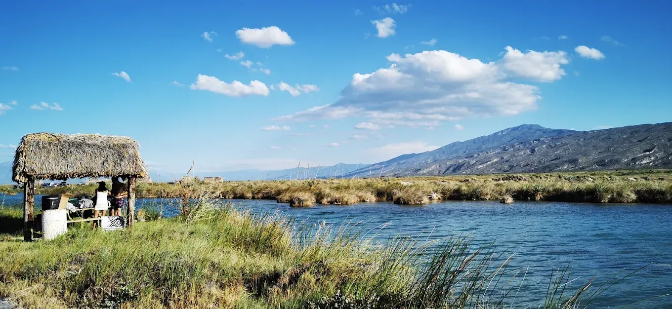 Una pequeña cabaña está situada en la orilla de un lago.