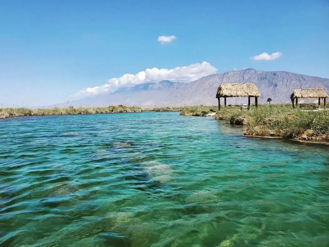 Hay dos chozas con techo de paja en medio de un lago.