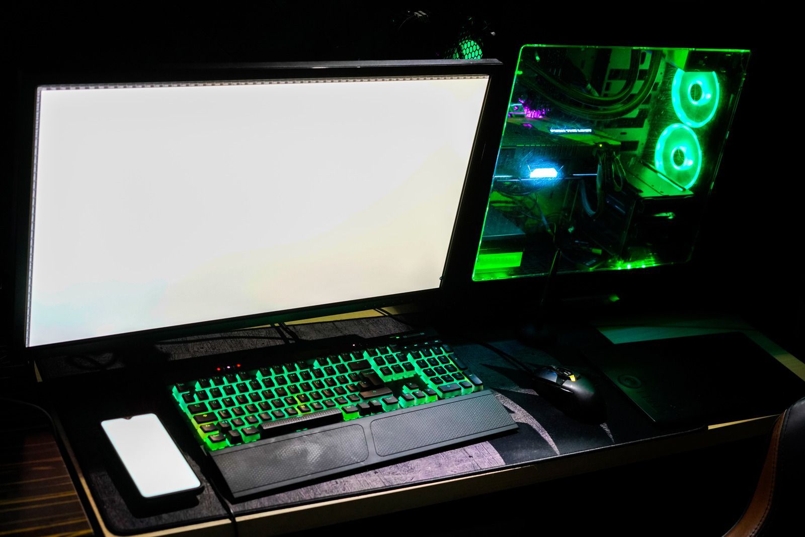 A computer setup on a table. A red screen with blue lines, keyboard, and monitor.