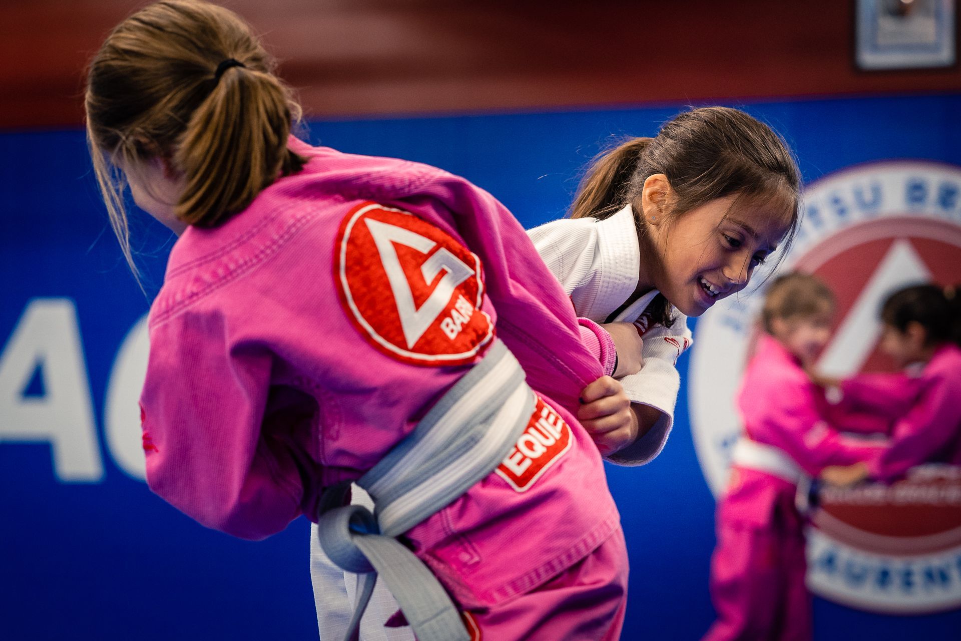 A group of young girls are practicing takedowns.