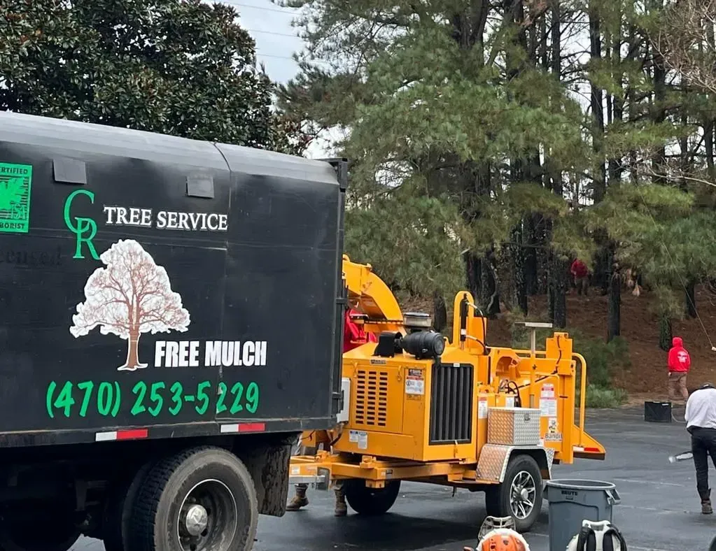 A tree service truck with a tree chipper attached to it