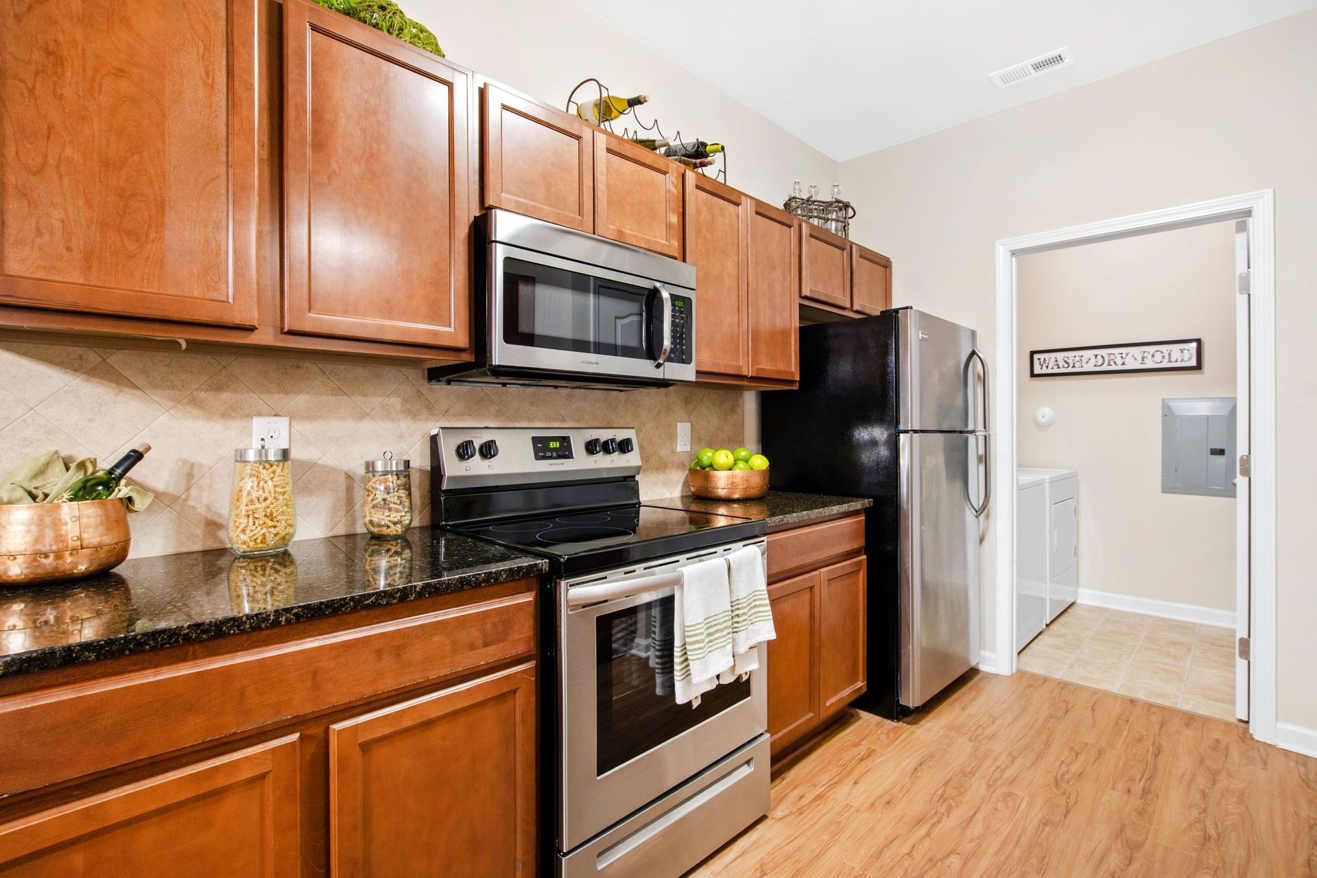 Kitchen with wooden cabinets, stainless steel appliances, and granite countertops.