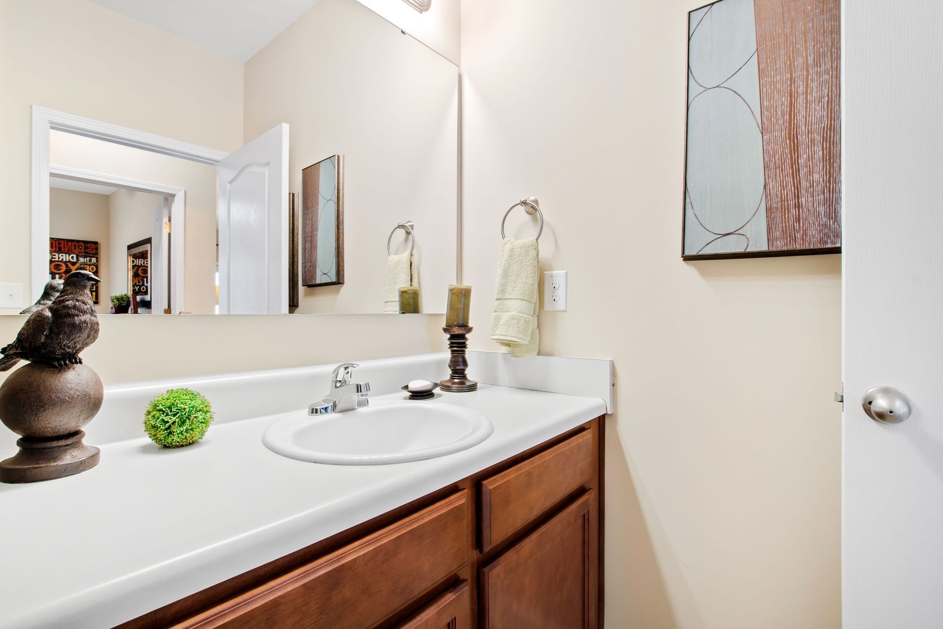 Bathroom vanity with sink, large mirror, and towel ring in an apartment.