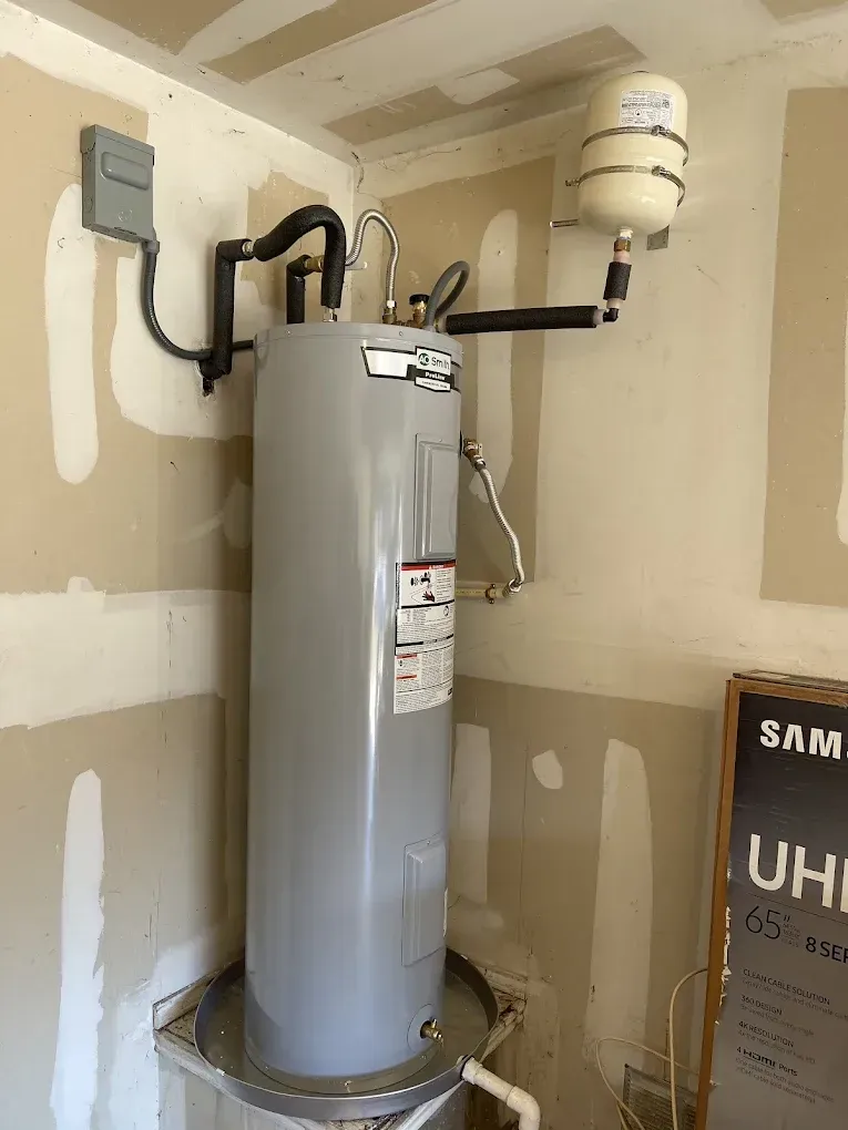 A water heater is hanging on a wall in a room.