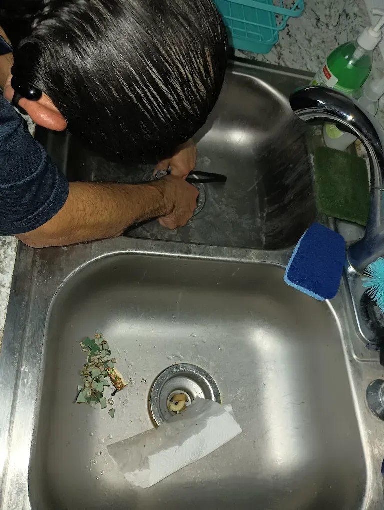 A man is washing his hair in a kitchen sink