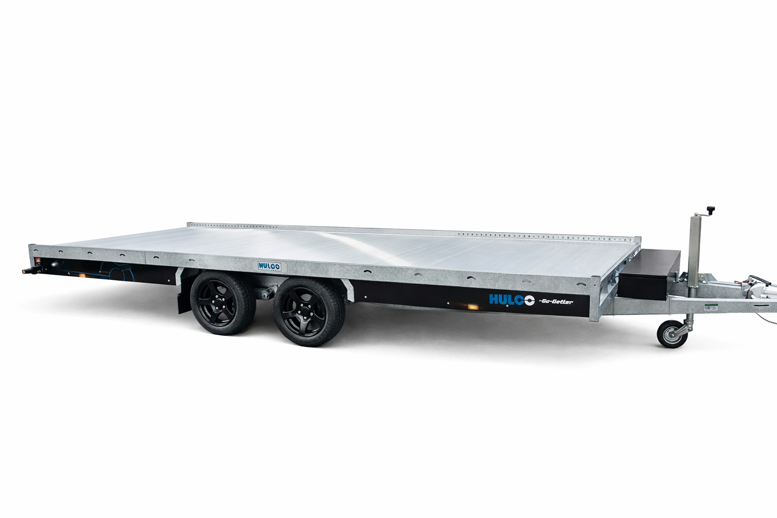 Een zilverkleurige, platte tandemasser-aanhanger met zwarte velgen tegen een effen witte achtergrond.