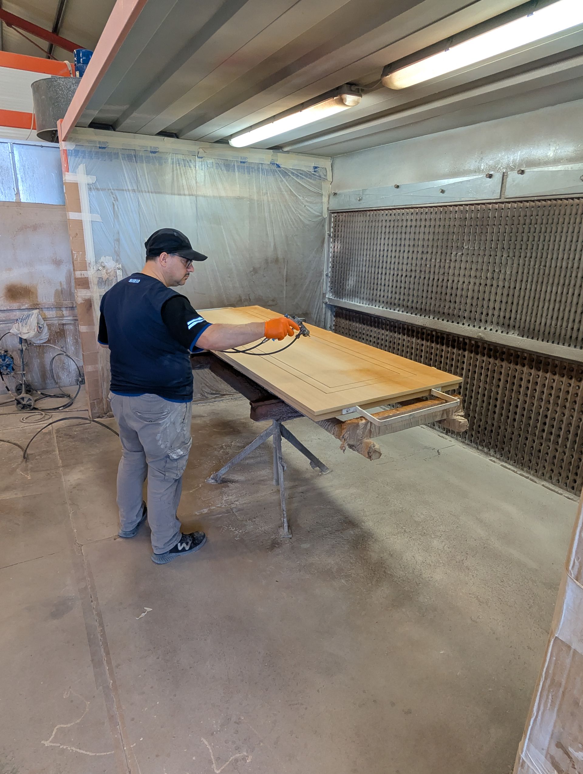 Un uomo lucida una porta di legno