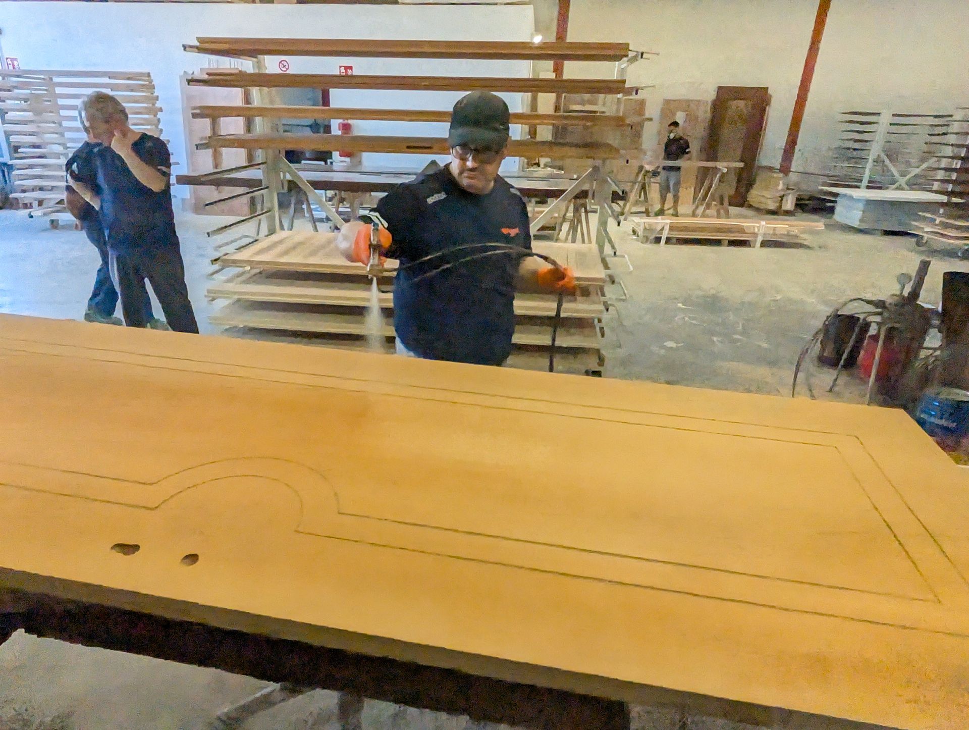 Un uomo sta spruzzando un pezzo di legno in una fabbrica