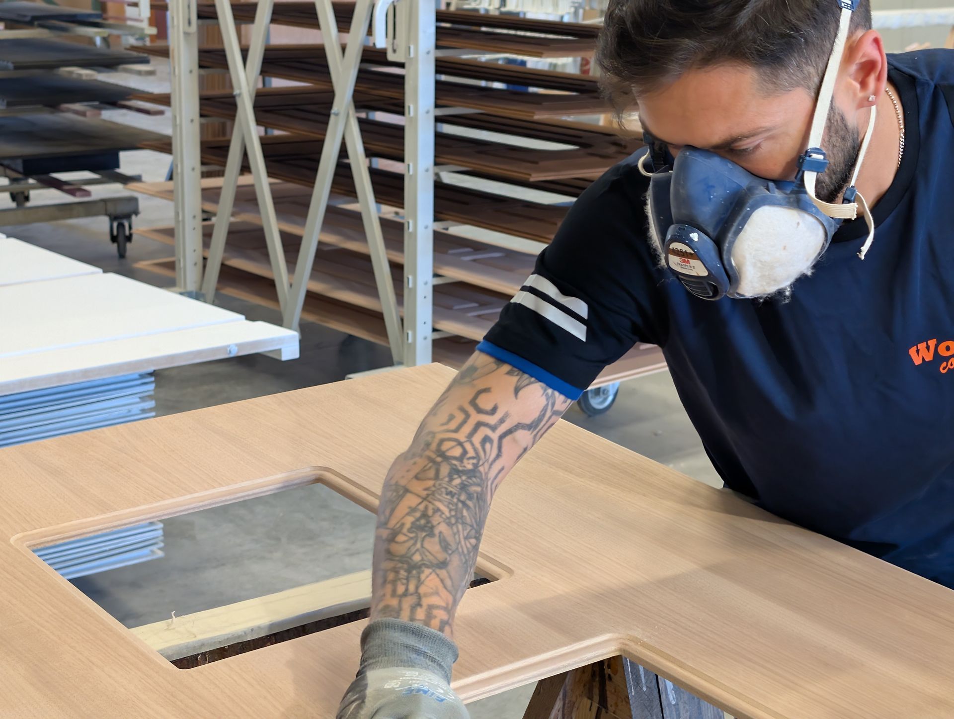 Un uomo che indossa una maschera sta verniciando una porta di legno