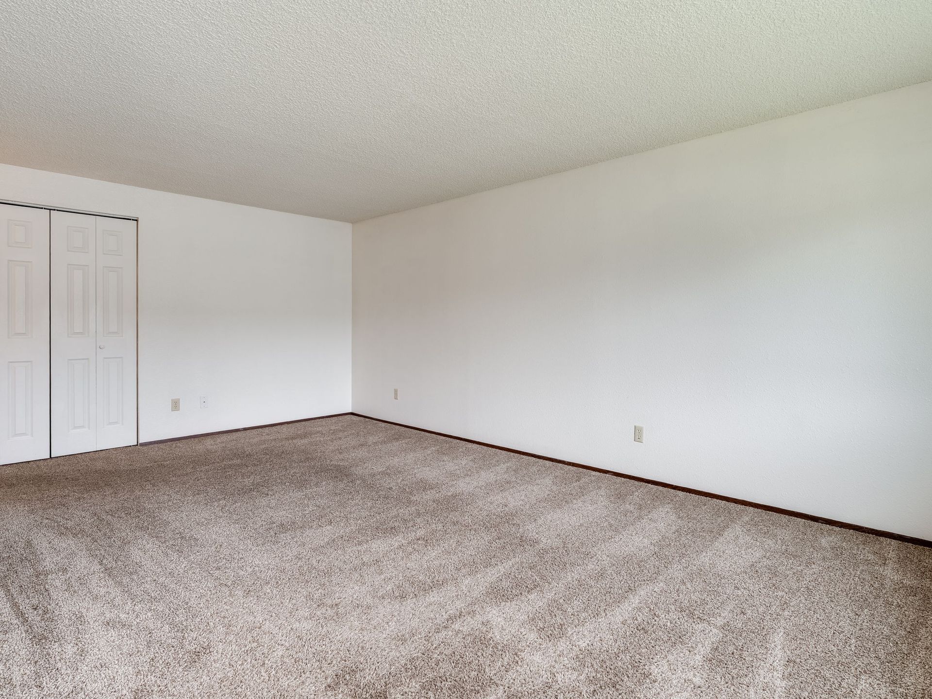 Southridge Apartments 2Bed/1Bath spacious living room with view of storage closet closed.