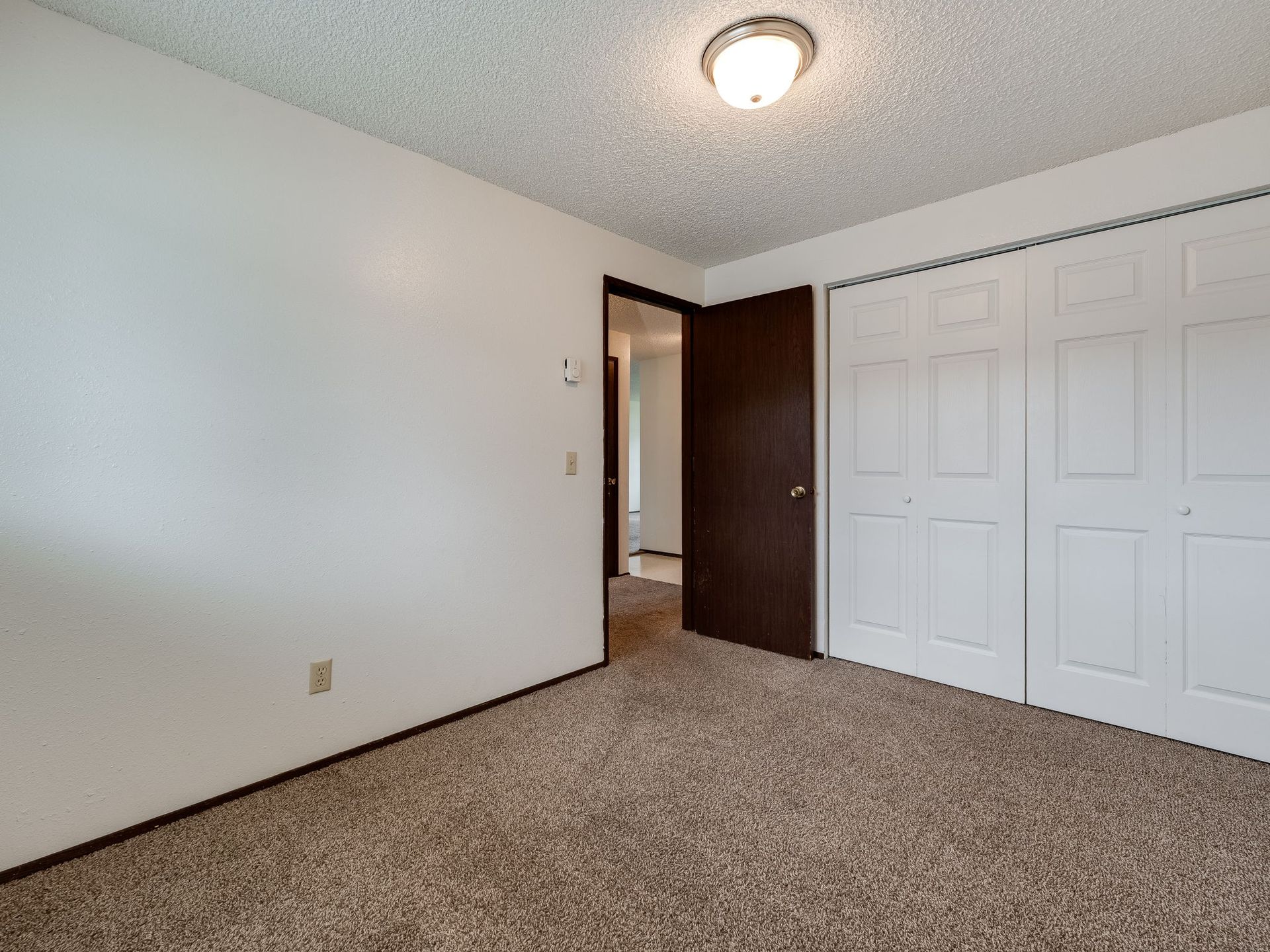Southridge Apartments 2Bed/1Bath bedroom 2 with view of door and closed closet.