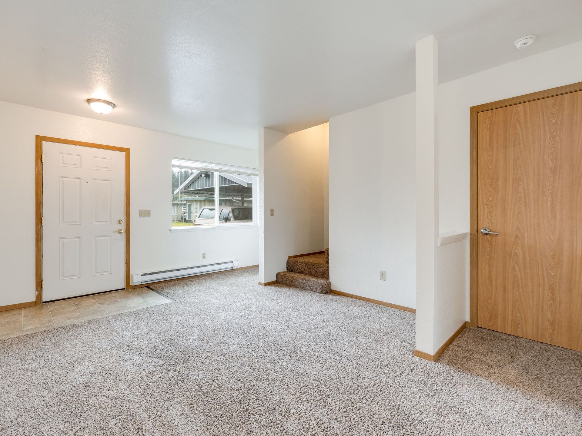 Southridge Apartments Townhome living room with view of window, closet and stairway.