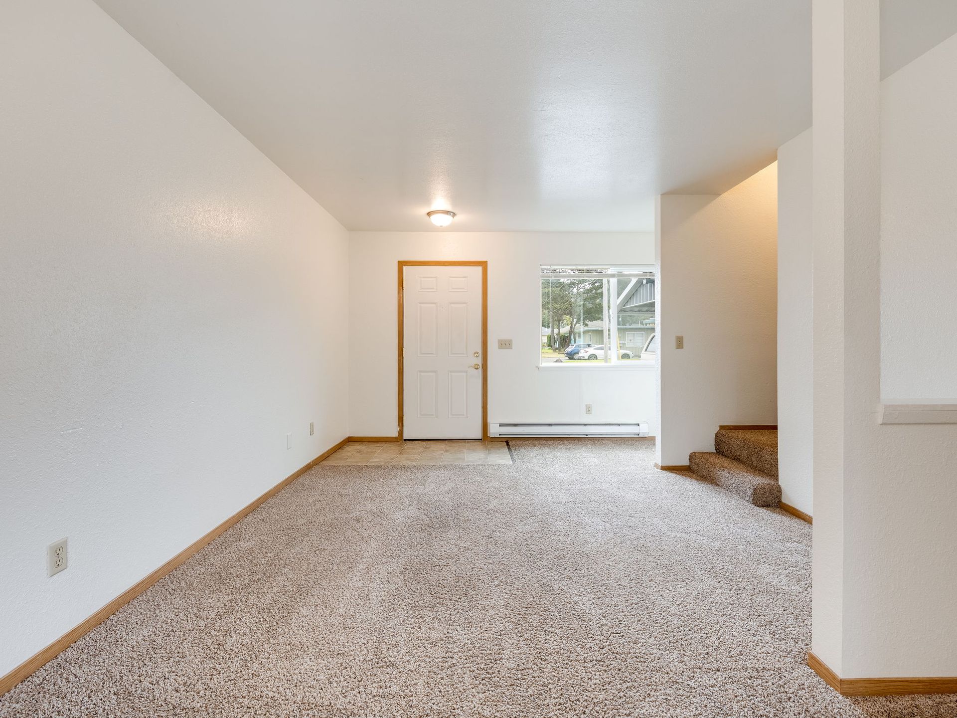 Southridge Apartments Townhome spacious living room with view of front door and window.