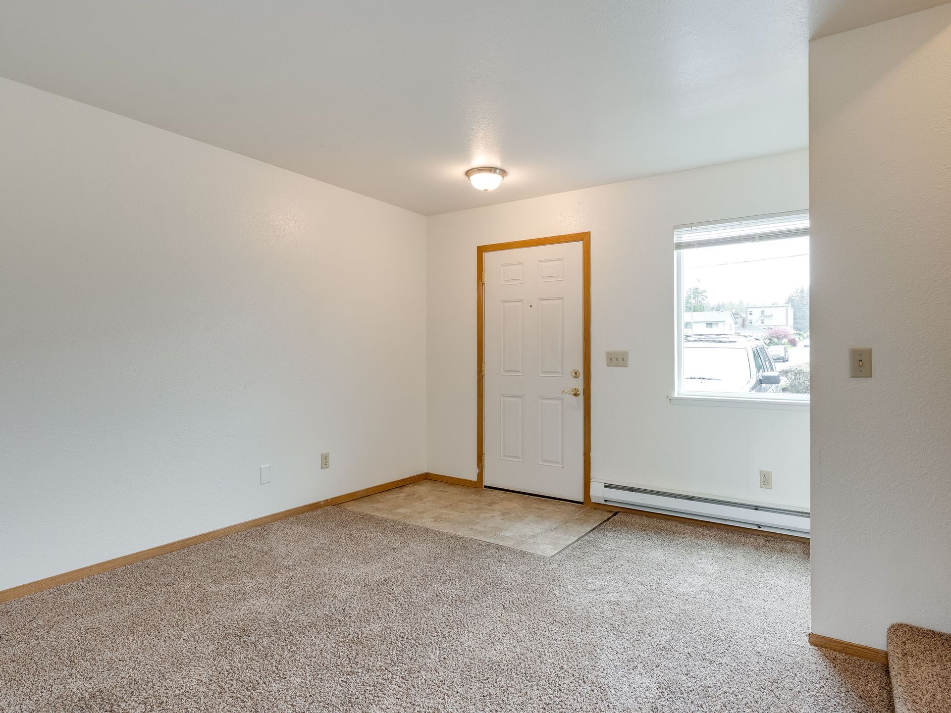 Southridge Apartments Townhome spacious living room with view of front door and window.