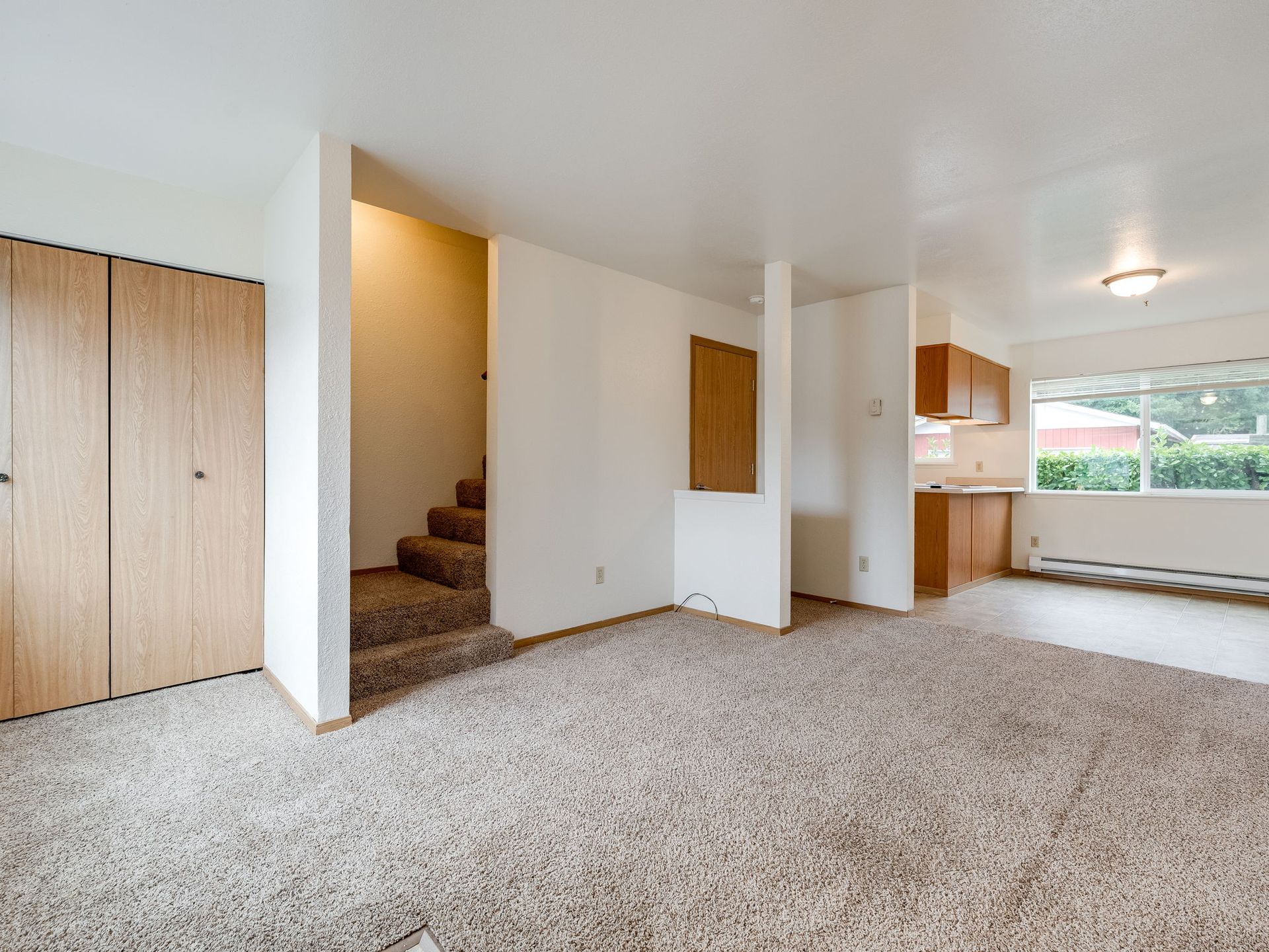 Southridge Apartments Townhome spacious living room with view of stairway and kitchen.