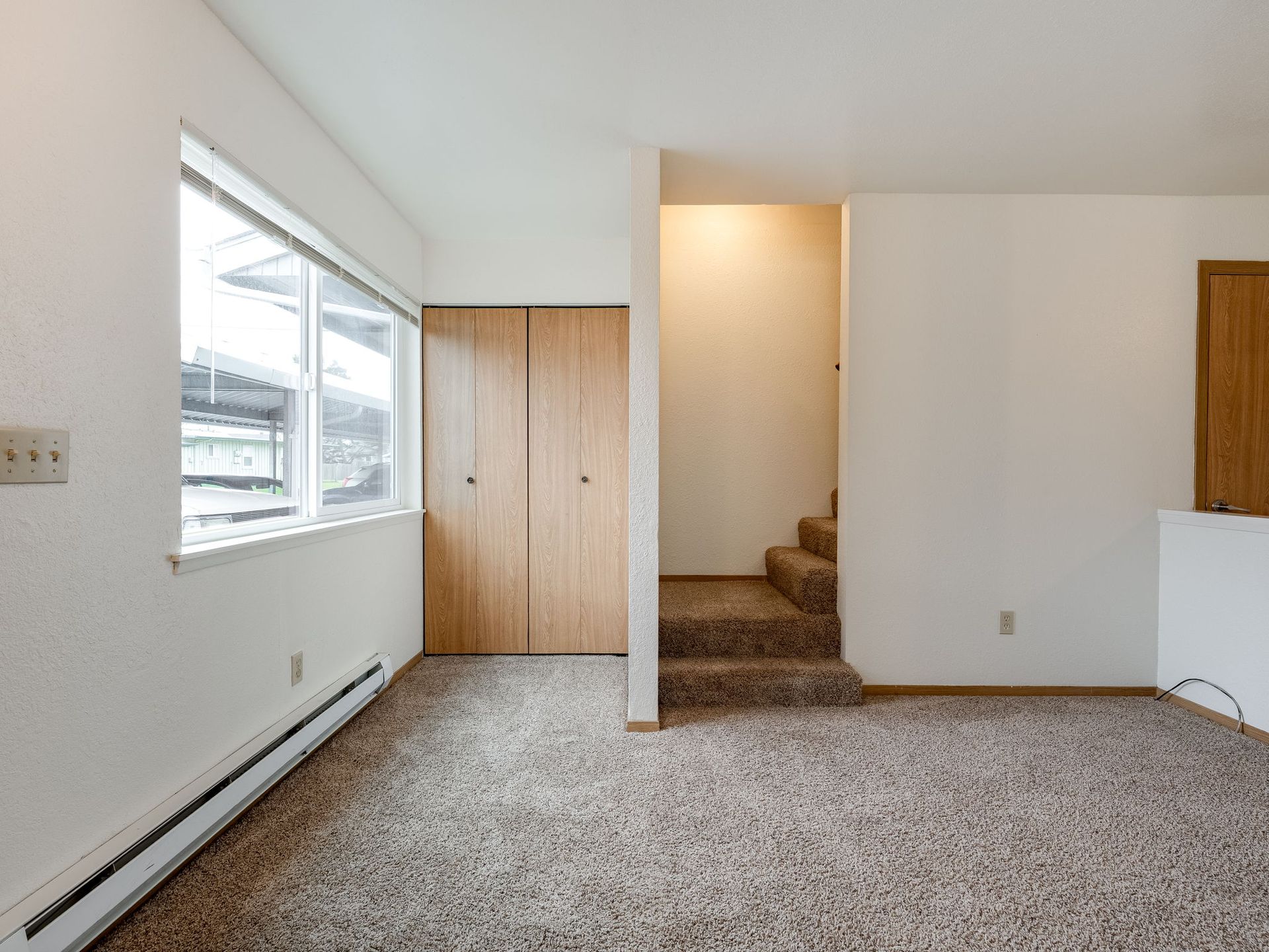 Southridge Apartments Townhome spacious living room with view of window, closet and stairway.