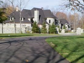 A Large House With A Black Roof Is Sitting On Top Of A Lush Green Field | Manilla, IN | Floyd Crim & Sons Paving