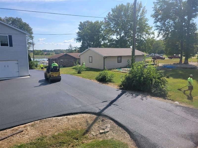 A Group Of People Are Working On A Driveway In Front Of A House | Manilla, IN | Floyd Crim & Sons Paving